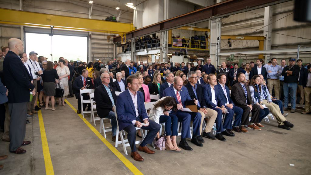 People sitting and standing in an audience at Jacksonville Ship Repair