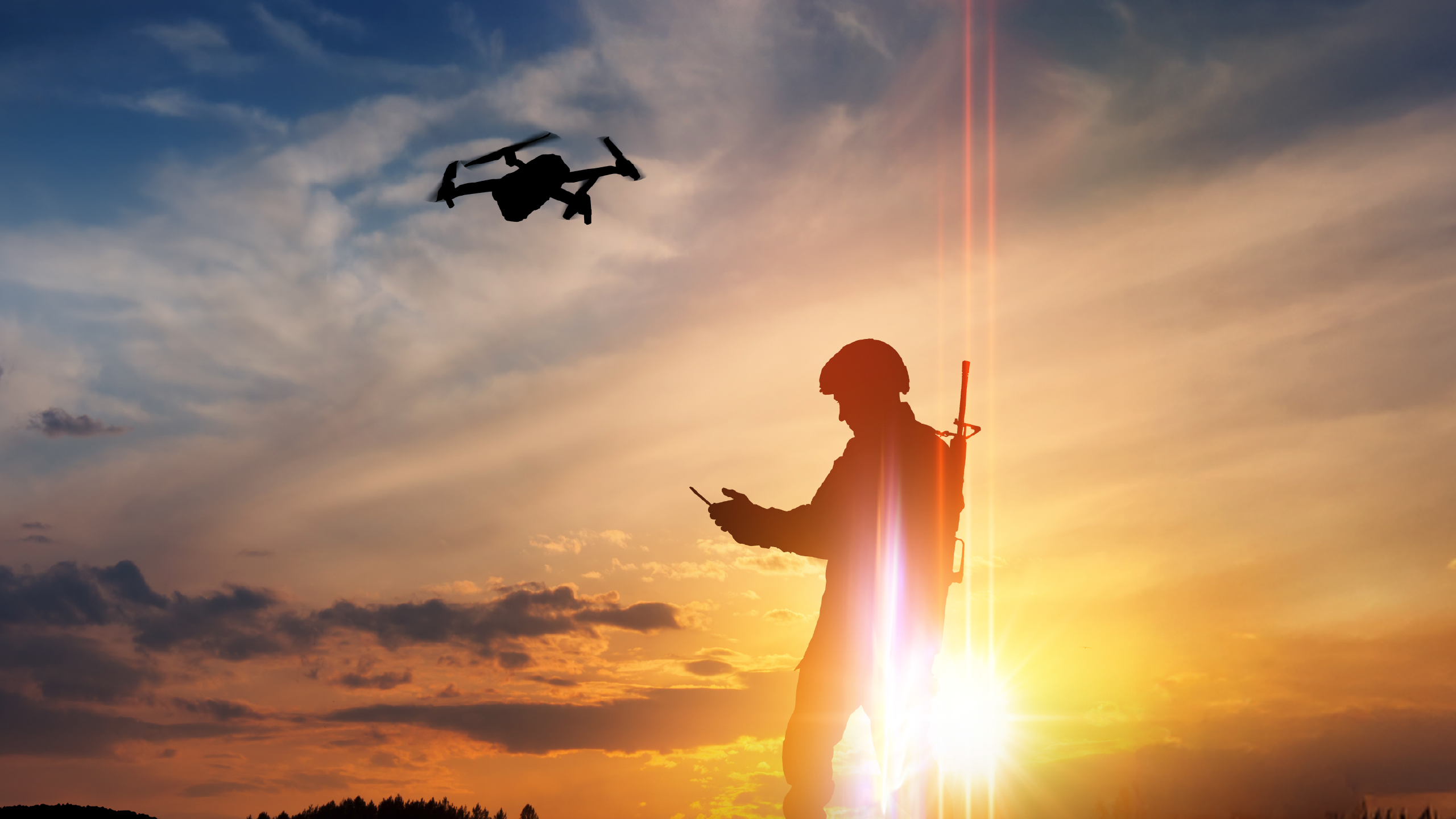 Soldier flying a drone at sunset