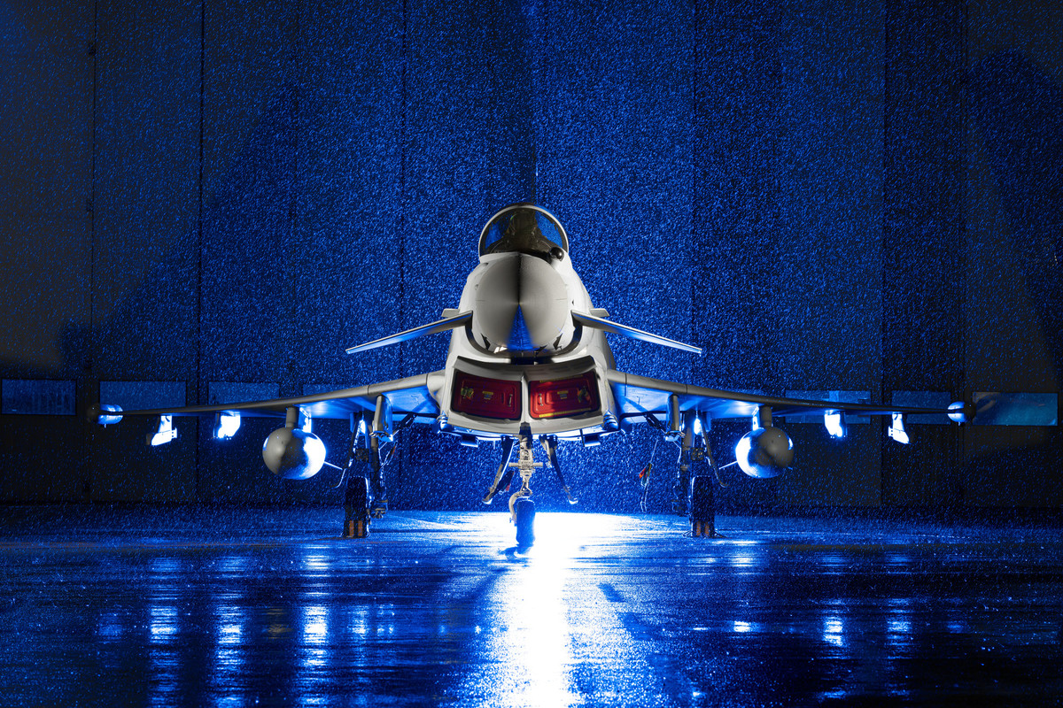 A Typhoon aircraft on a runway at night in the rain