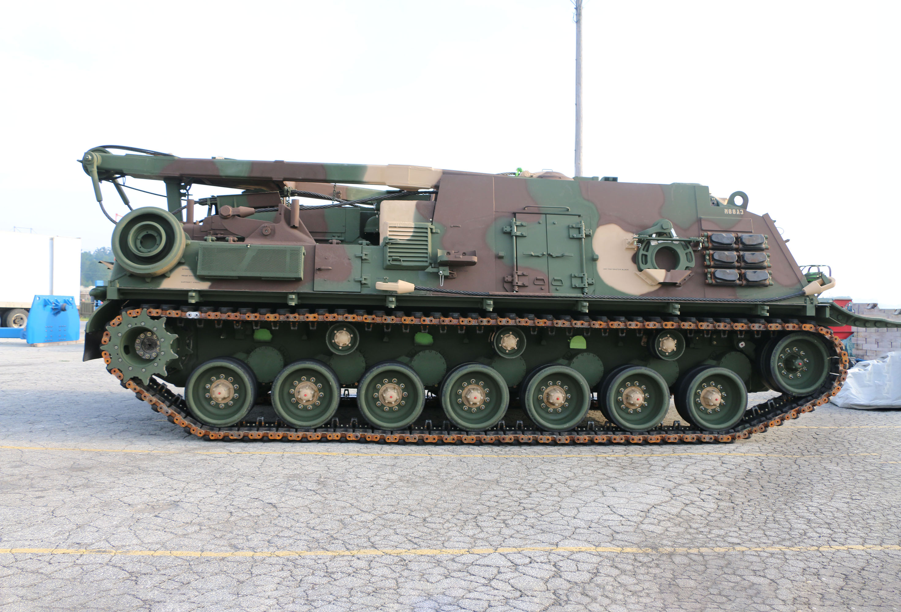 A brown, green, and tan camouflage M88A3 viewed from the side