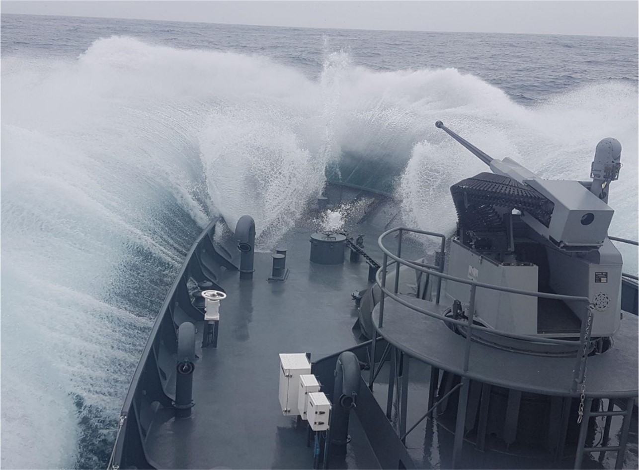 30mm Machine Gun System aboard a ship with ocean spray around it