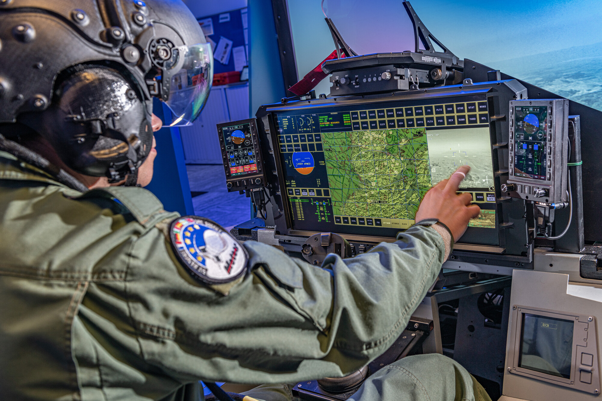 A pilot touching a display screen in a Typhoon simulator in a training facility