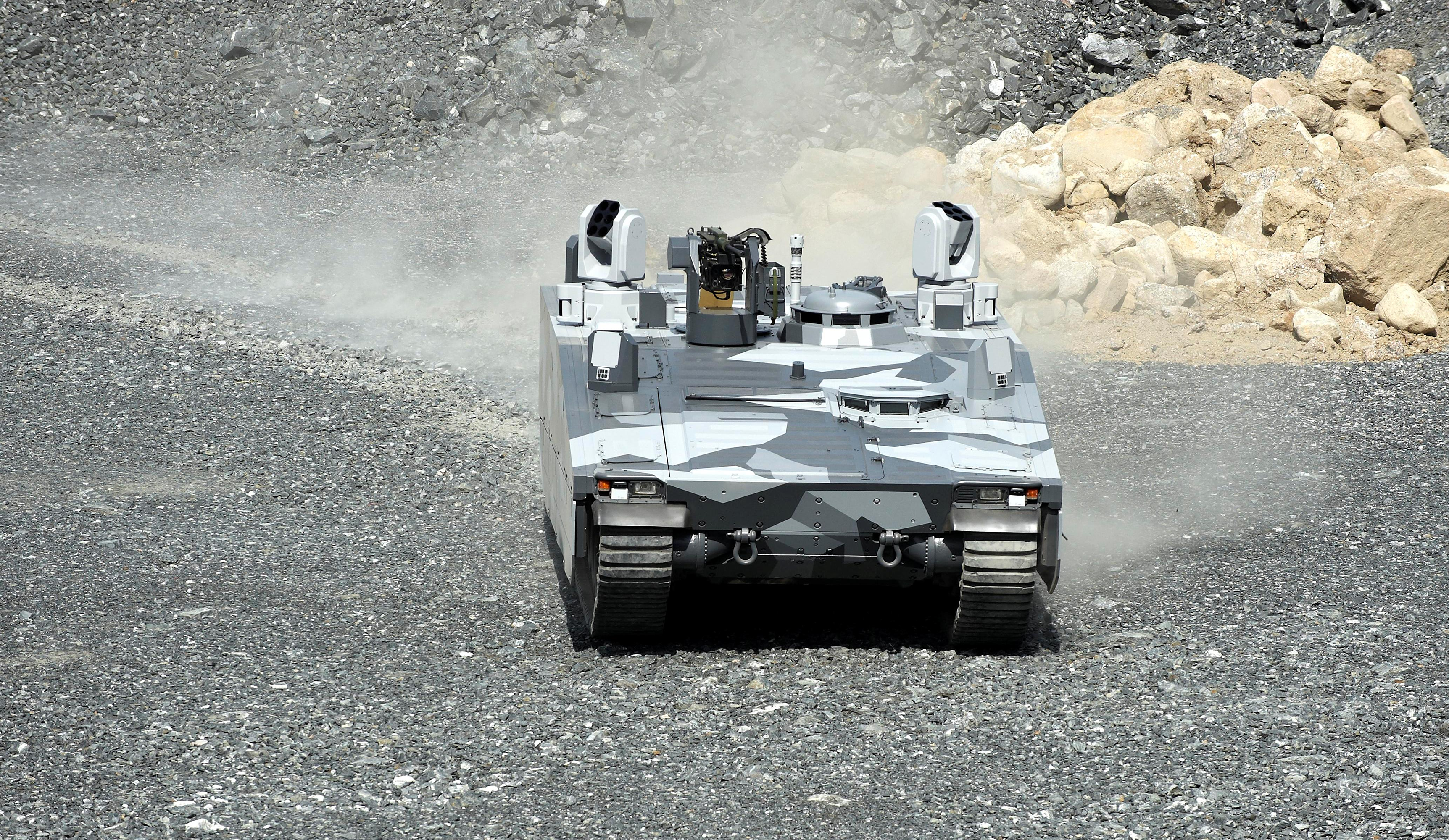 A gray camouflage CV90 Armadillo on a gravel road