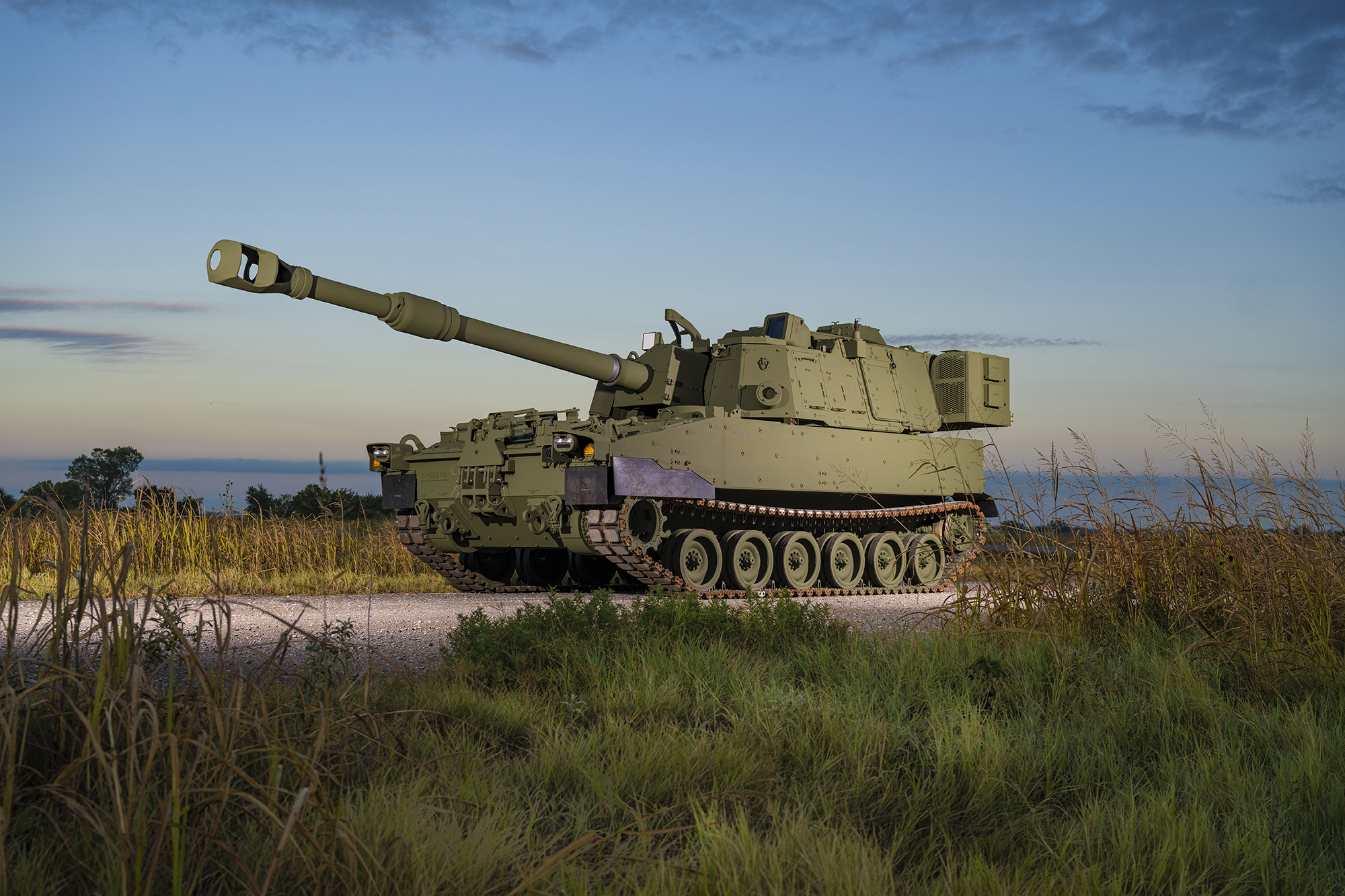 M109A7 in the field with a sunset of orange hues and grass