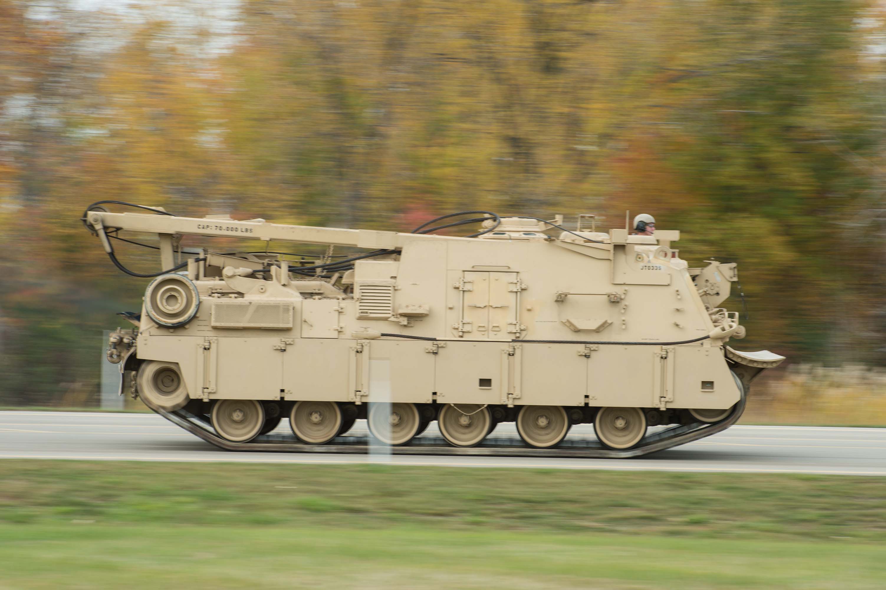 A tan M88A2 driving down the road