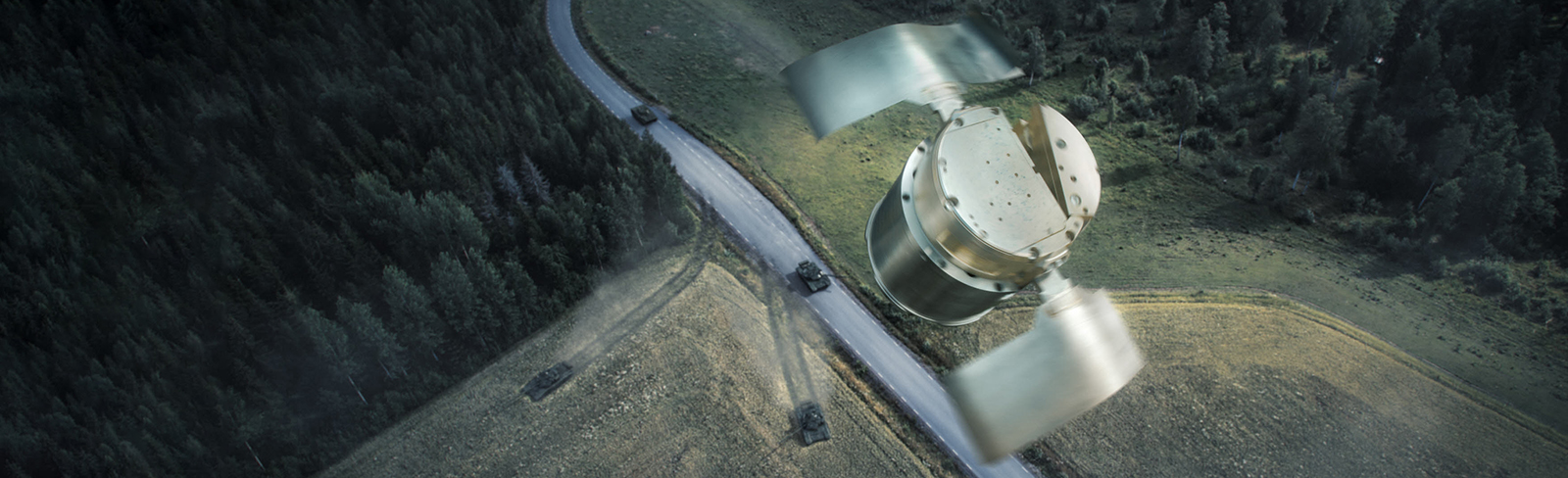 Concept of BONUS in the air with tanks driving on a road and fields lined by trees below
